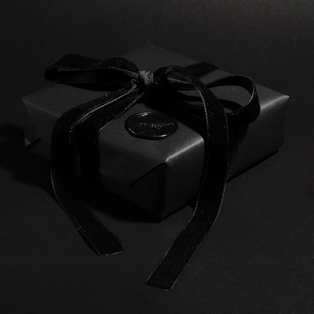 confezione regalo nera con nastro in velluto nero e sigillo in ceralacca