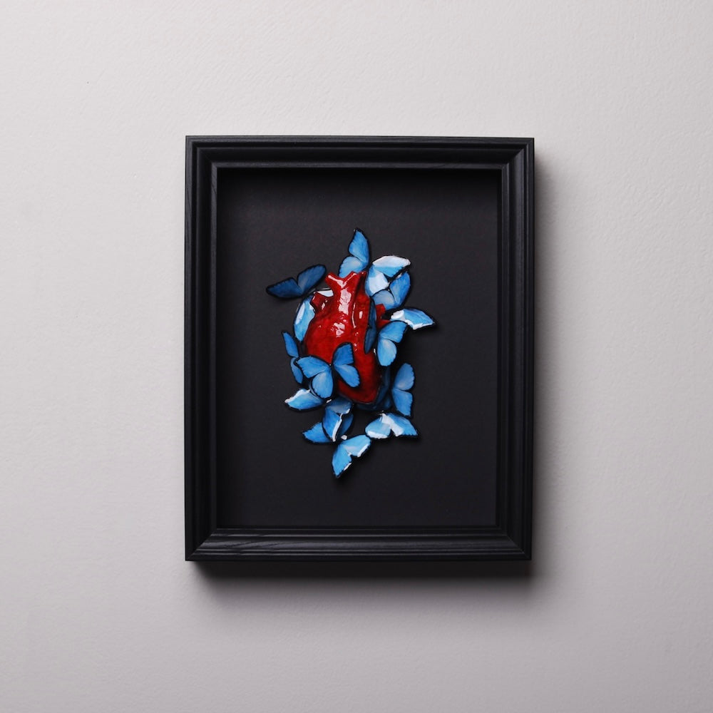 quadretto con cuore anatomico e sciame di farfalle blu