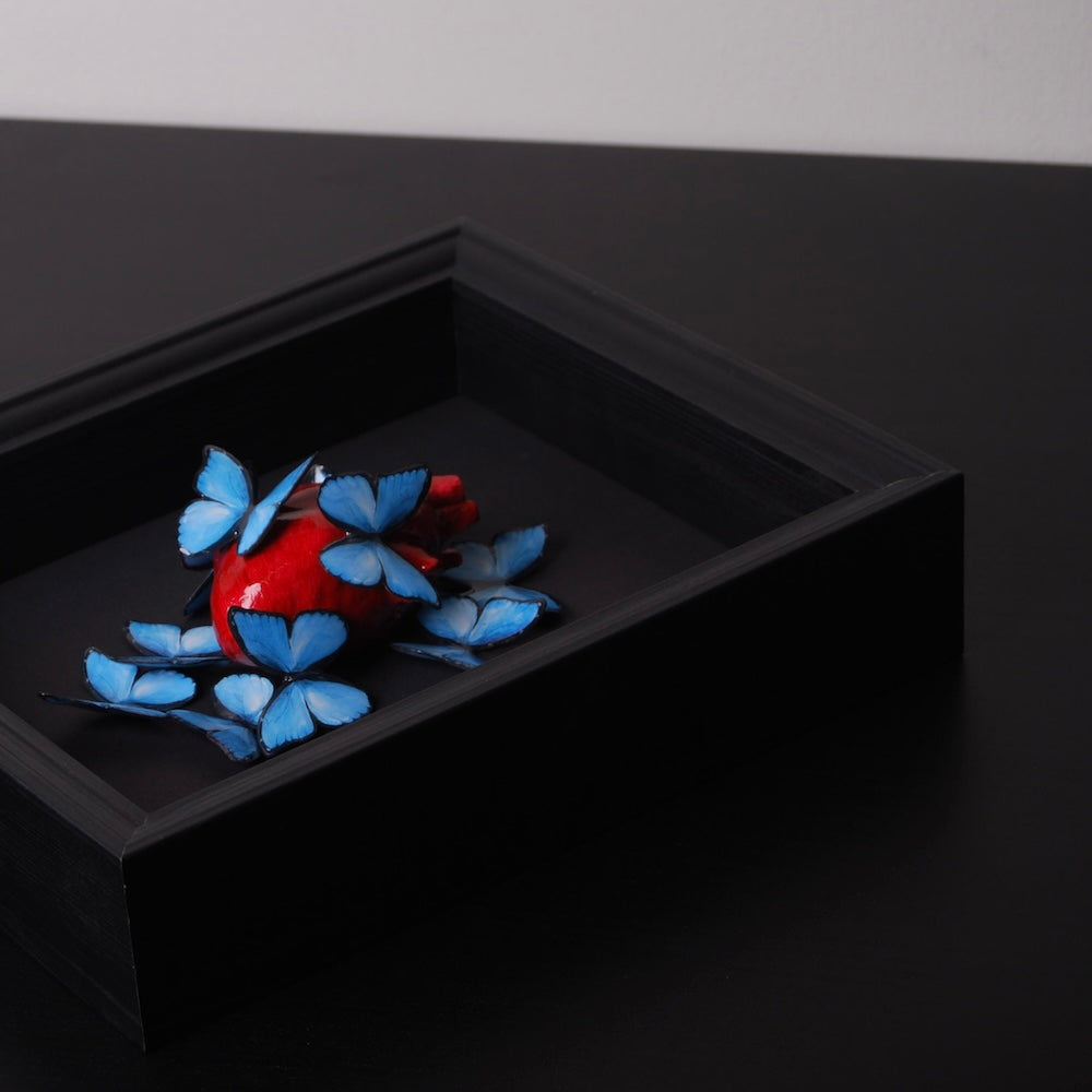 quadretto con cuore anatomico e sciame di farfalle blu, vista laterale