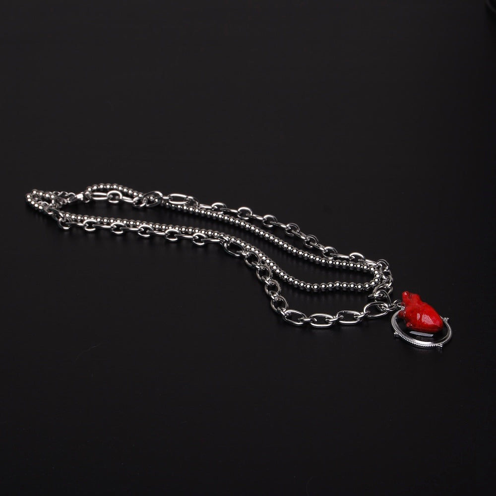 collana a catena doppia con pendente ovale con cuore anatomico rosso, vista 3/4