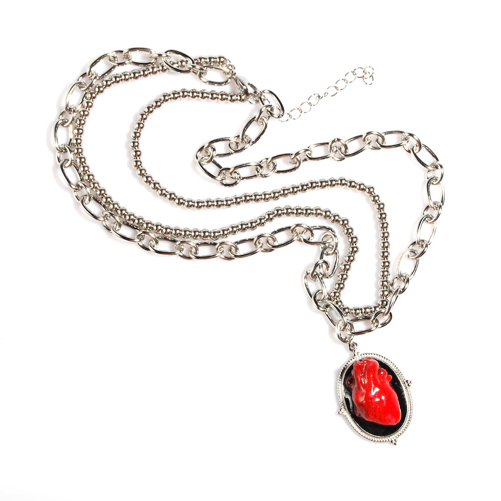 collana a catena doppia con pendente ovale con cuore anatomico rosso, vista dall'alto