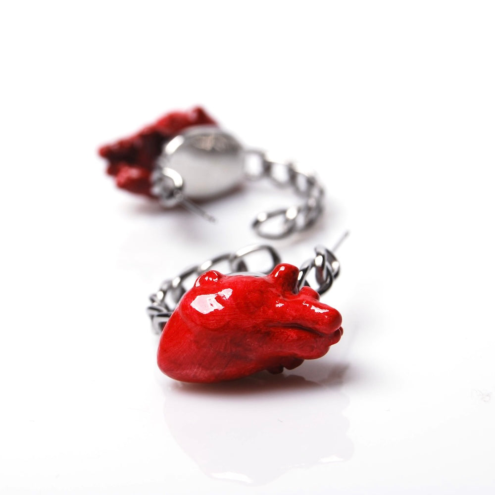 cuore rosso su un orecchino a cerchio a catena