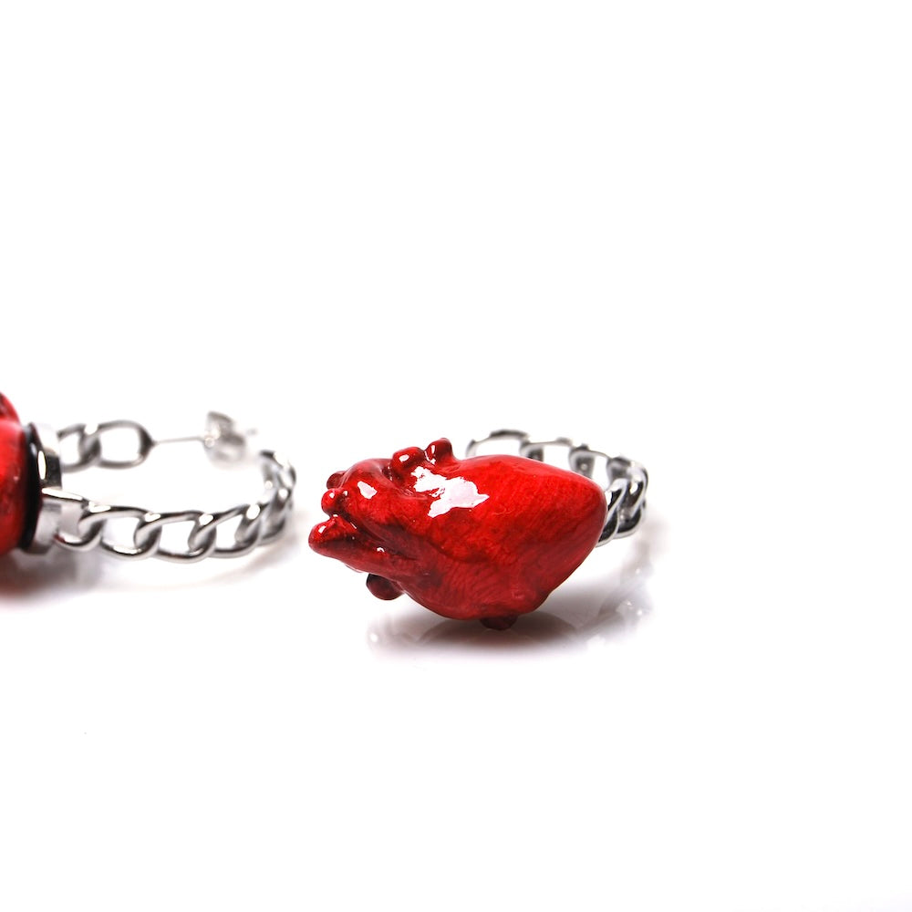 orecchini con cerchio a catena e cuore anatomico rosso, vista frontale di un orecchino