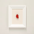 quadretto con cuore anatomico rosso su cornice rettangolare bianca