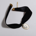 choker in velluto nero con pendente ovale con teschio bianco stile cammeo, vista dall'alto