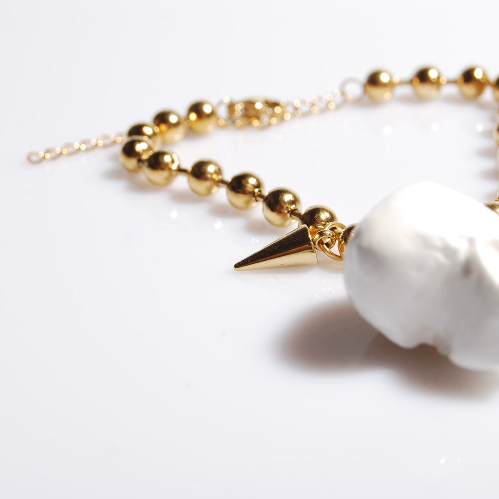 bracciale catena a sfere con pendente teschio bianco e punte, dettaglio punte