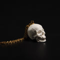 dettaglio del pendente teschio bianco di una collana a catena sottile