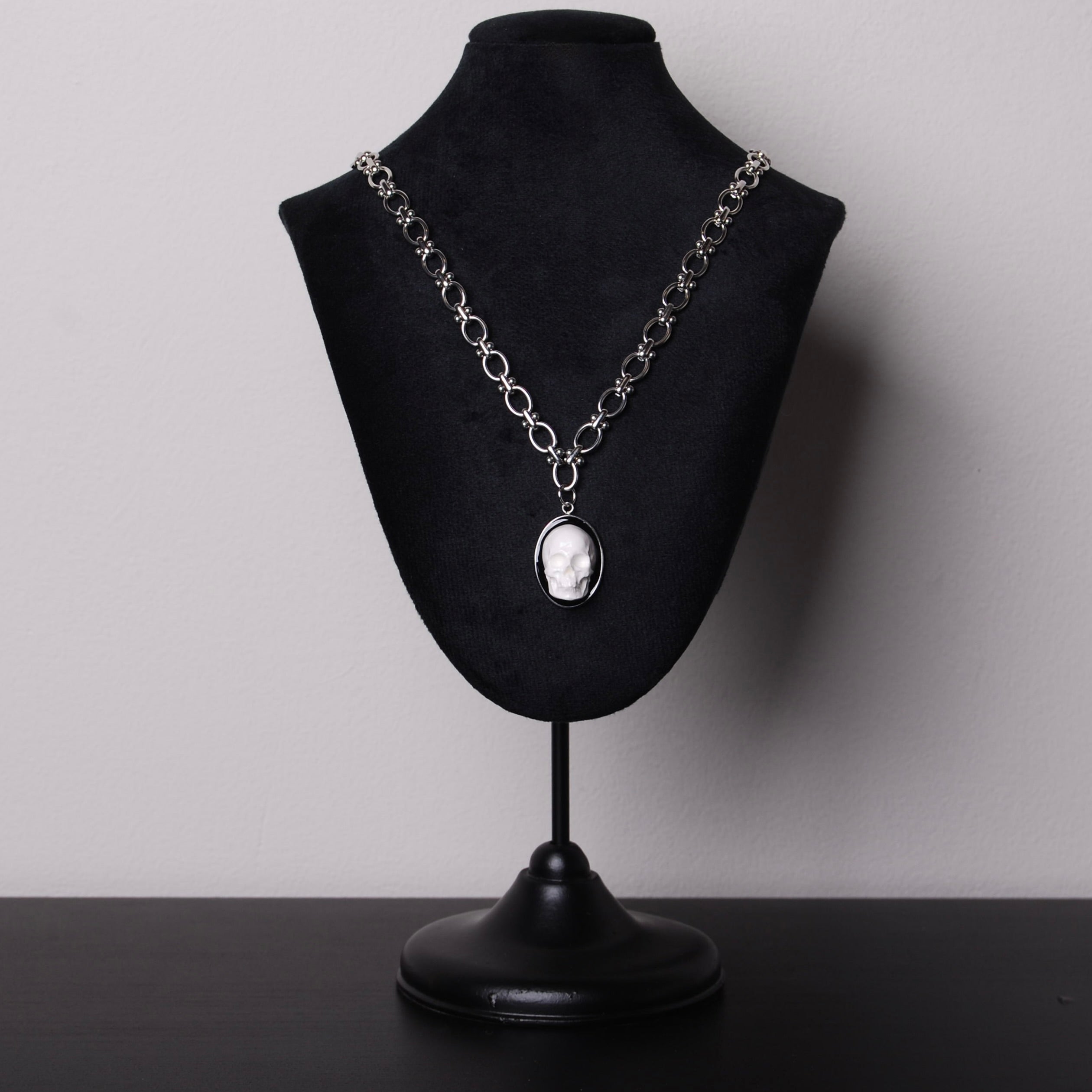 espositore con collana con catena spessa e pendente ovale con teschio bianco stile cammeo
