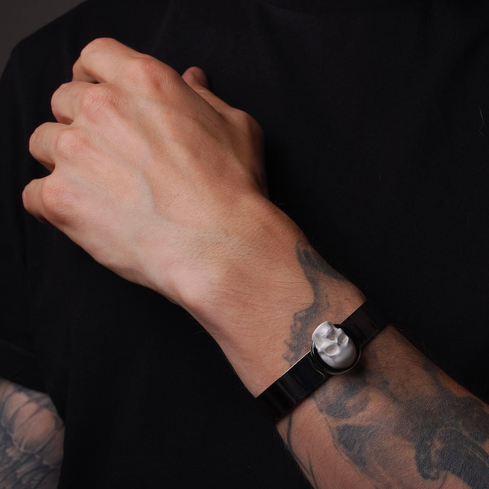bracciale rigido con teschio cammeo indossato su polso maschile tatuato