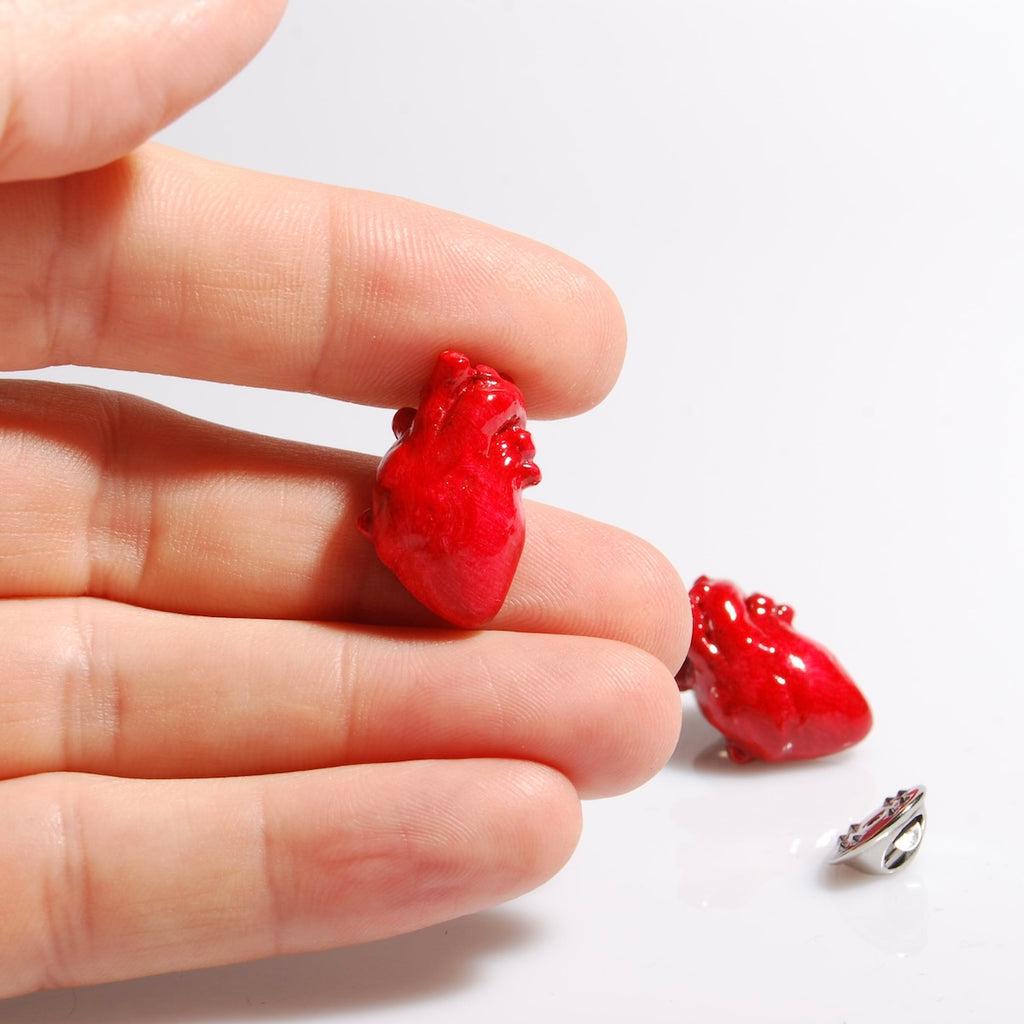spillette a forma di cuore anatomico rosso, una di queste è appoggiata sulle dita di una mano