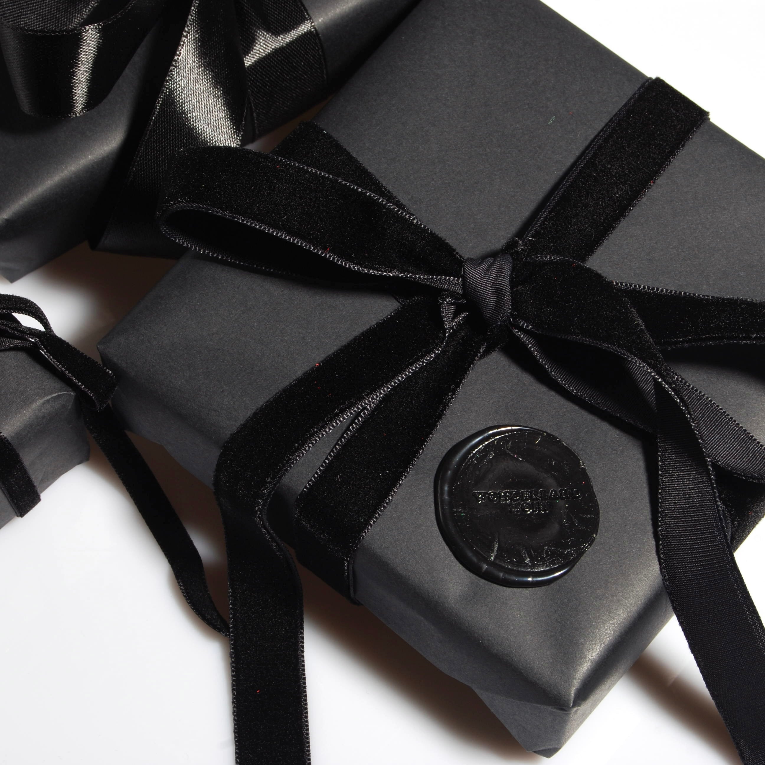 confezione regalo nera con nastro in velluto nero e sigillo in ceralacca