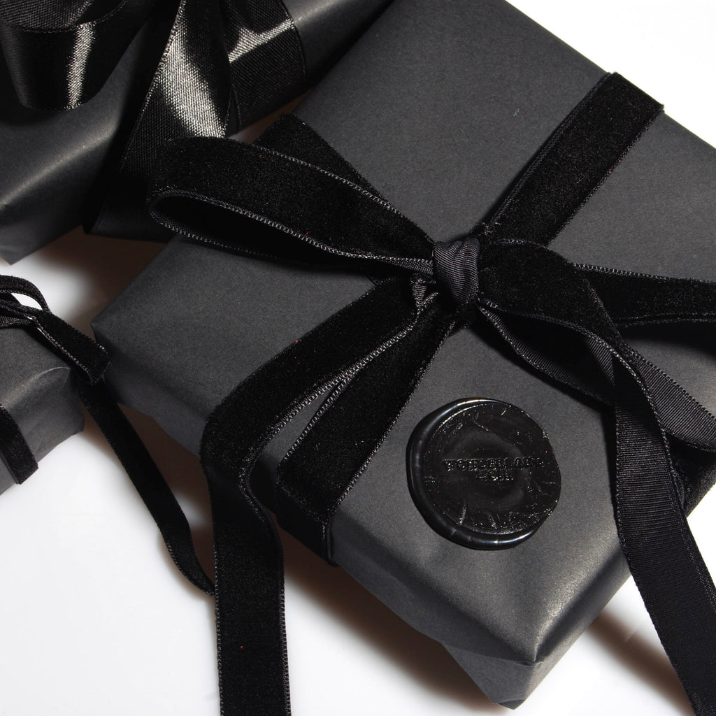 confezione regalo nera con nastro in velluto nero e sigillo in ceralacca con logo vista dall'alto