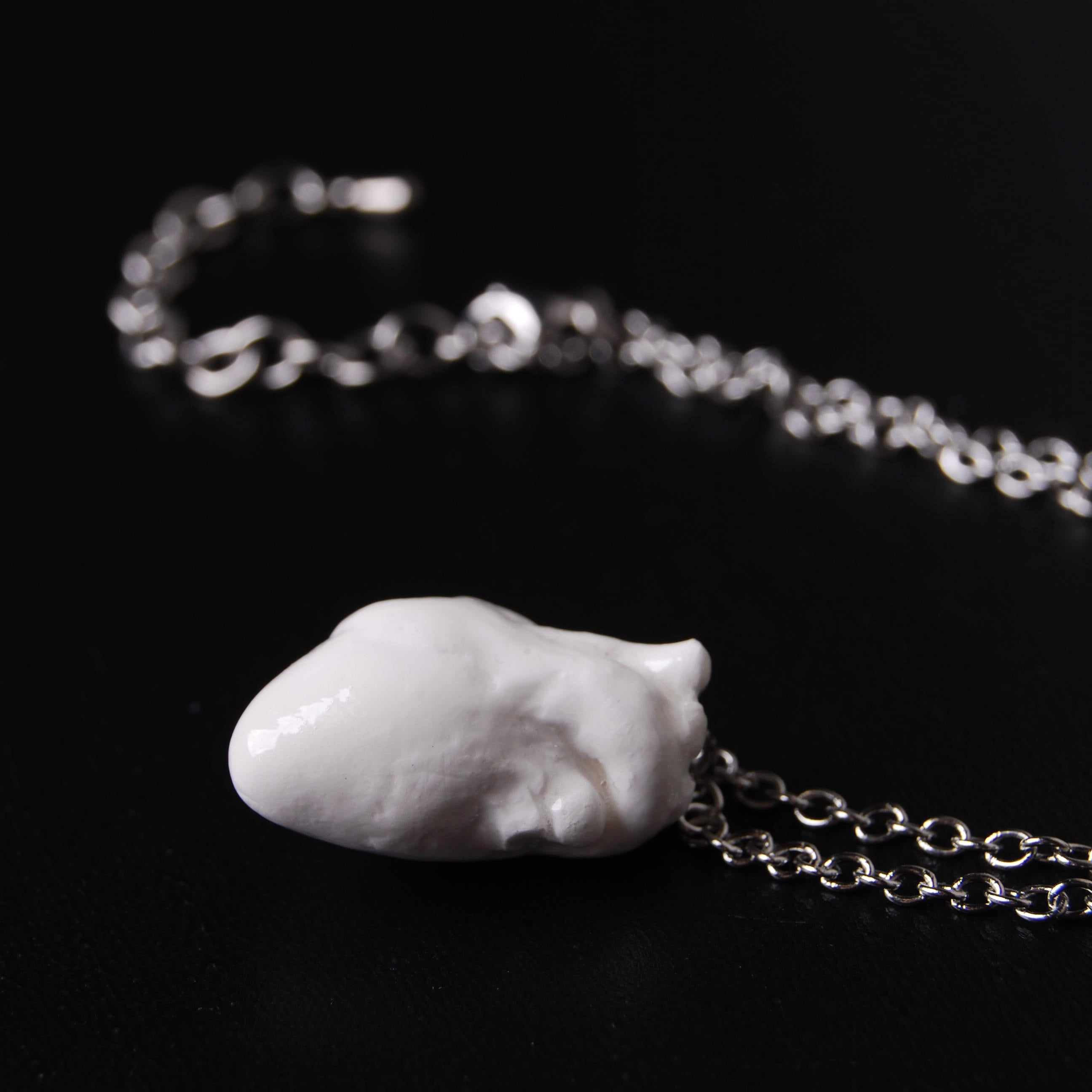 collana a catena sottile con pendente cuore anatomico bianco, vista laterale