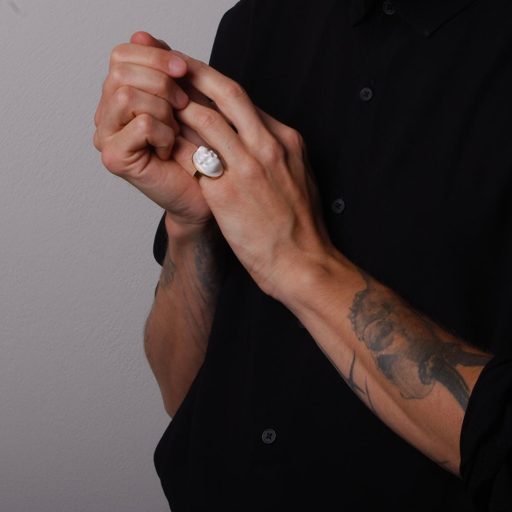 anello ovale con teschio stile cammeo indossato sul mignolo di una mano