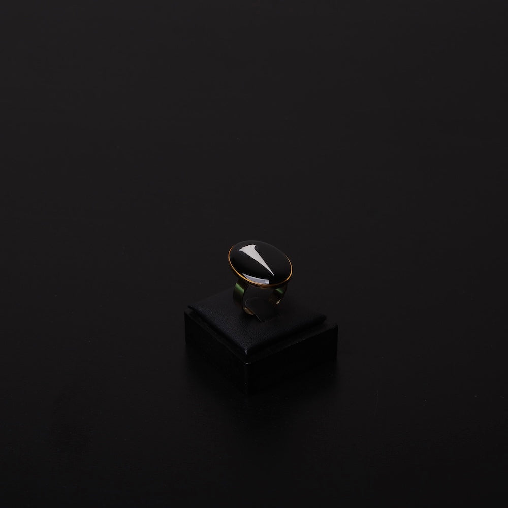 anello ovale con spina di acacia inglobata sotto resina, poggiato su porta anelli