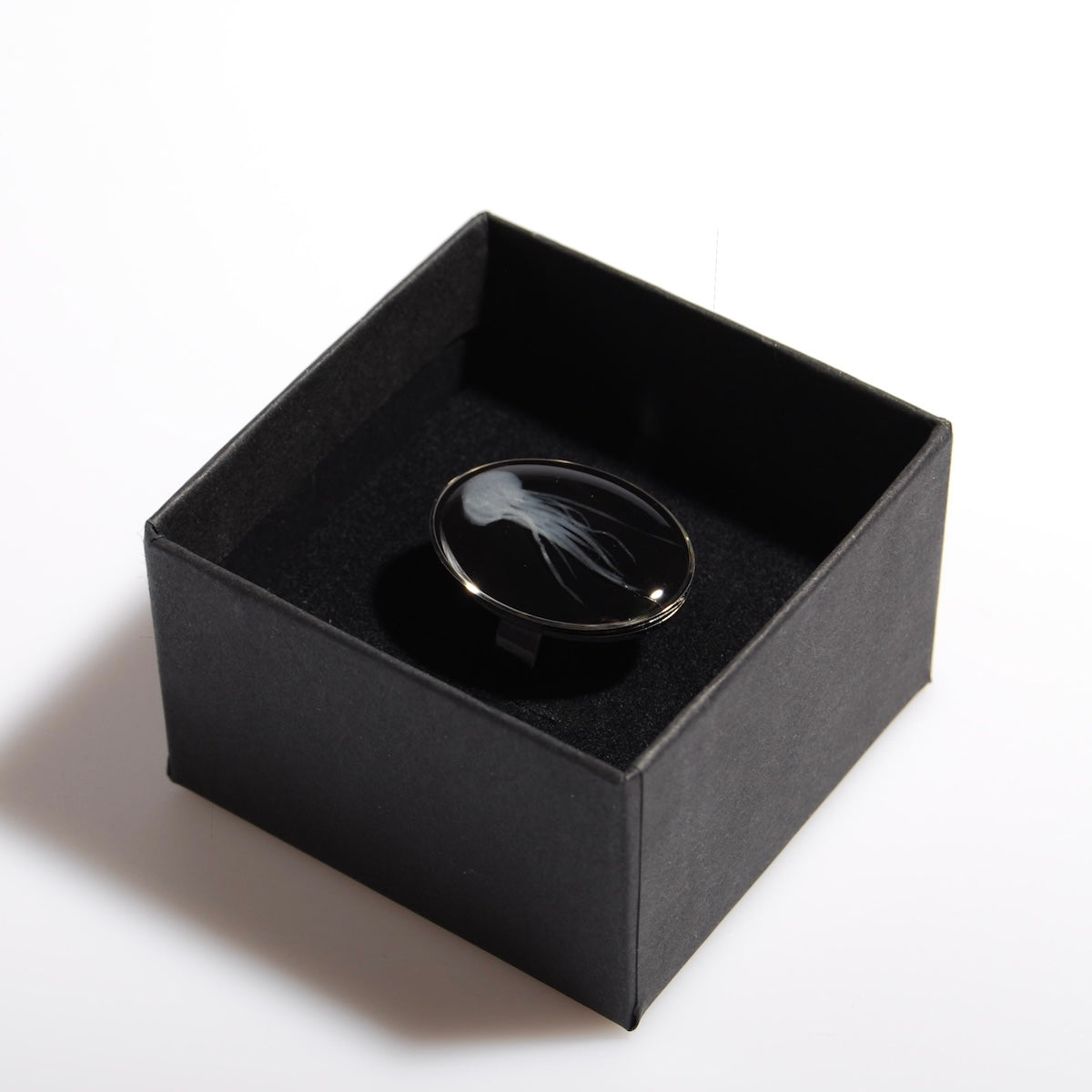anello ovale con medusa marina inglobata sotto resina dentro ad una scatolina nera