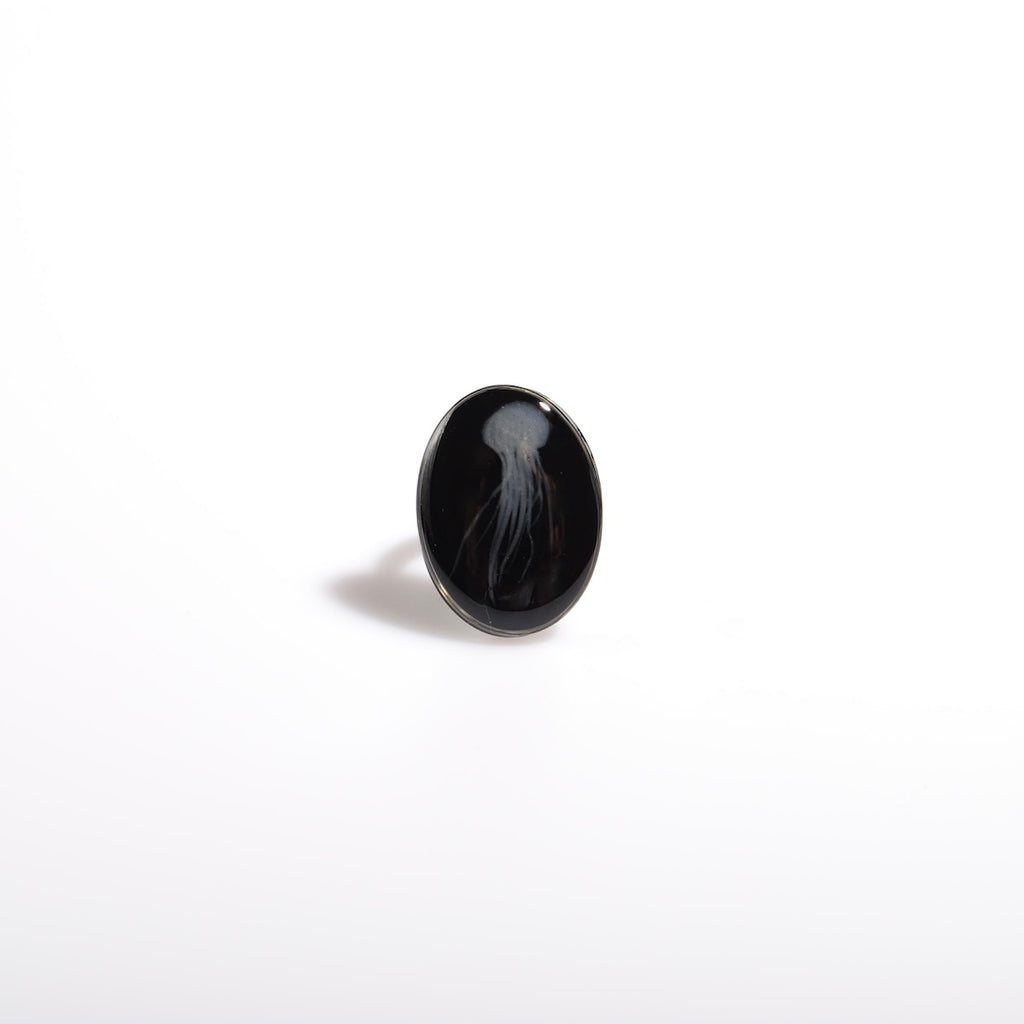 anello ovale con medusa marina inglobata sotto resina, vista frontale
