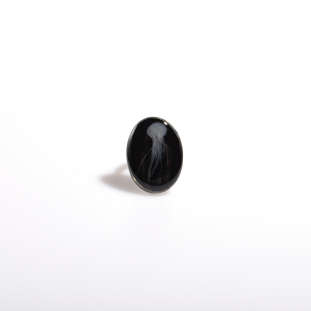 anello ovale con medusa marina inglobata sotto resina, vista frontale