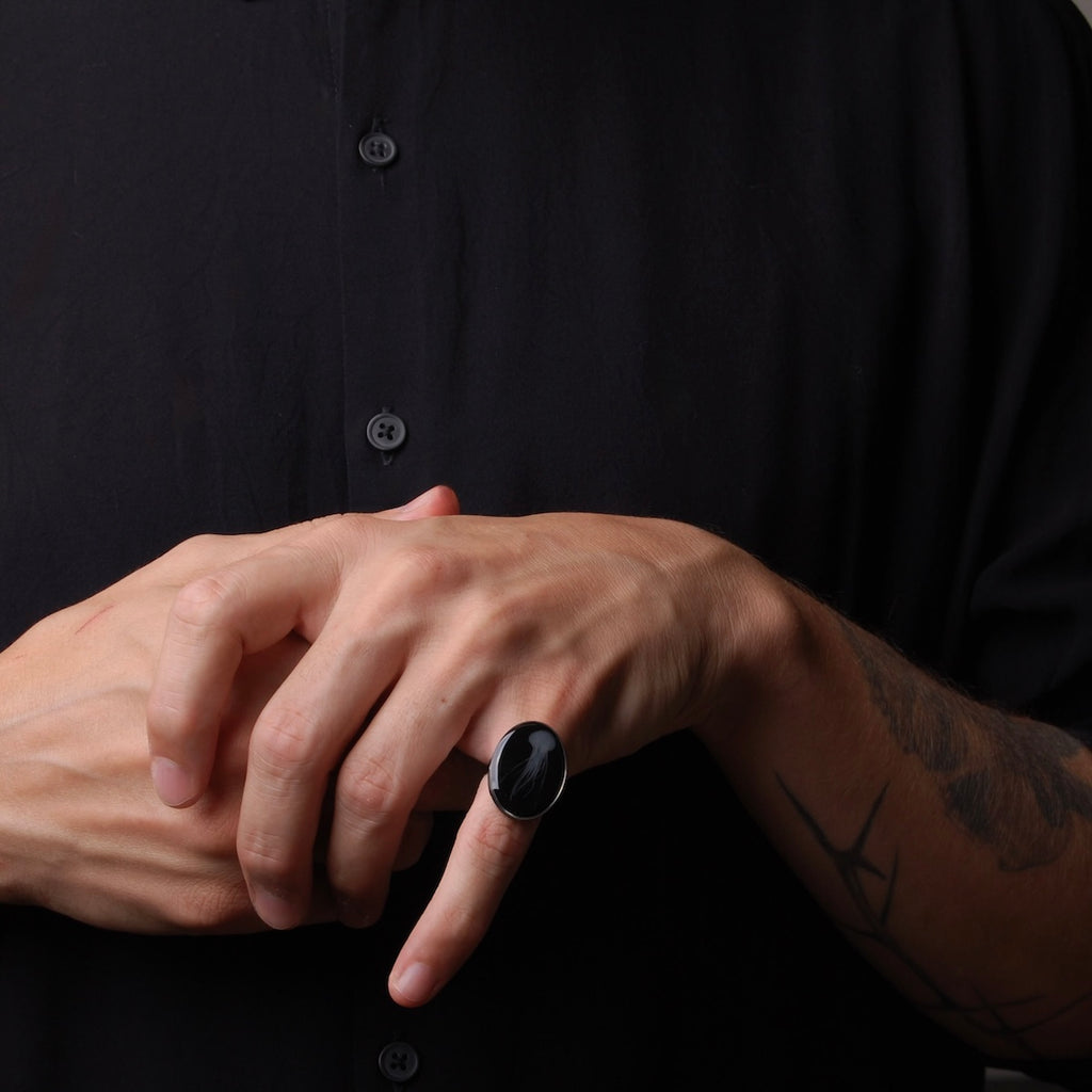 anello ovale con medusa marina inglobata sotto resina indossato su mano maschile