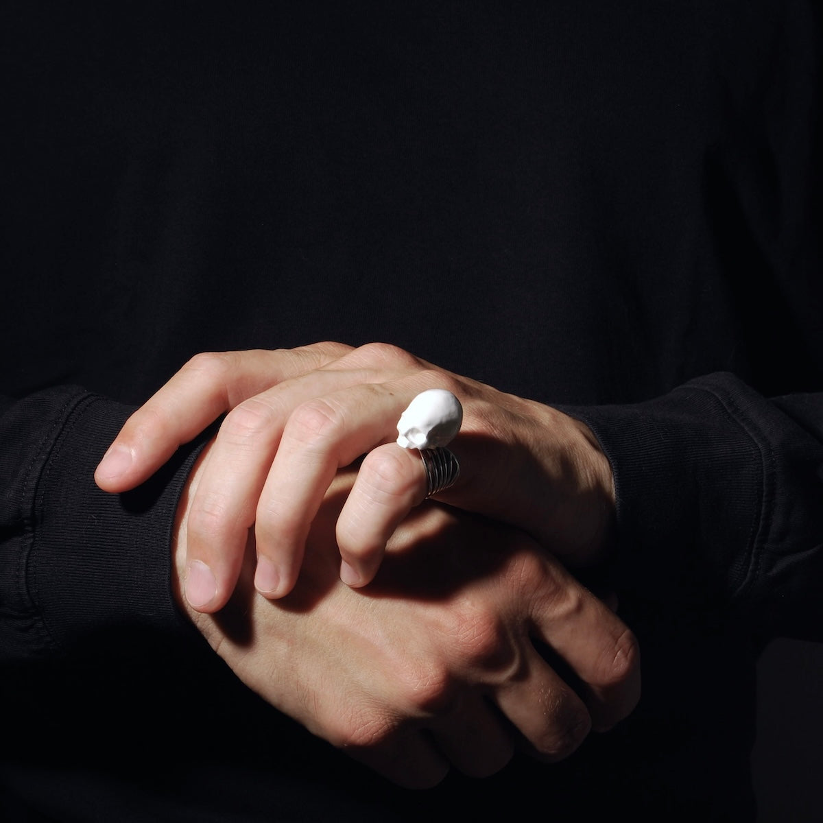 anello a banda larga con teschio bianco indossato su mano maschile