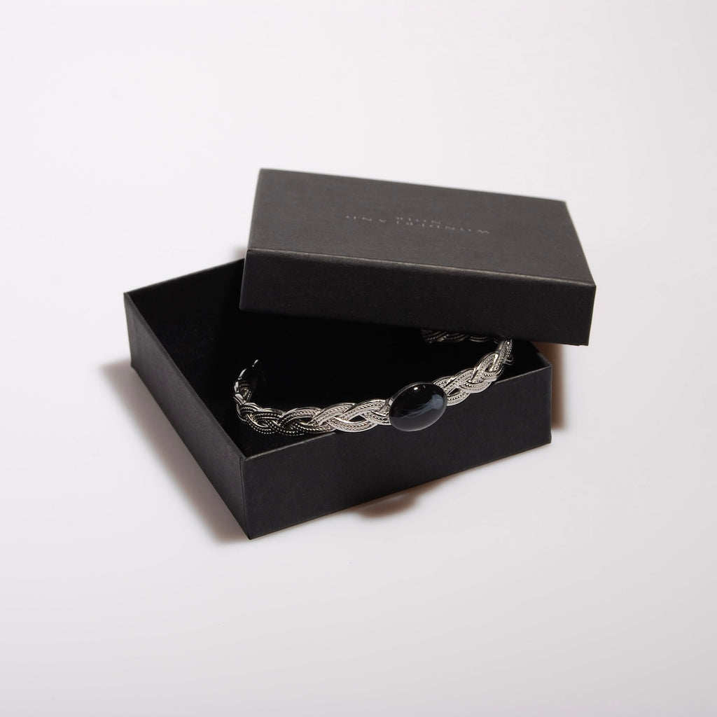 bracciale rigido intrecciato con ovale centrale con medusa marina inglobata sotto resina dentro ad una scatolina nera