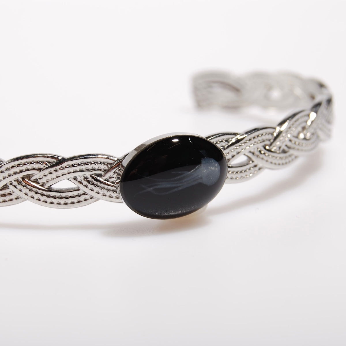bracciale rigido intrecciato con ovale centrale con medusa marina inglobata sotto resina, dettaglio dell'ovale