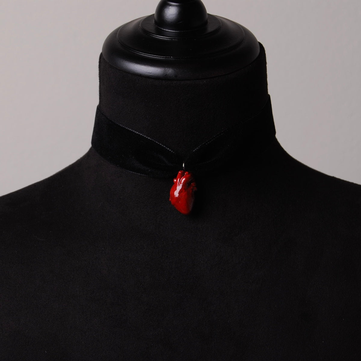 choker in velluto nero con cuore anatomico rosso su espositore