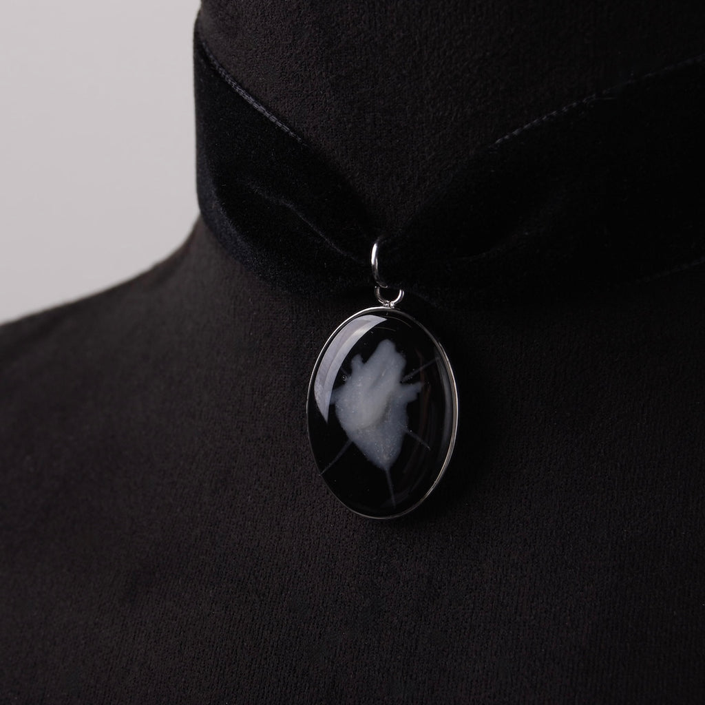 choker in velluto nero con ovale cuore anatomico spinato su busto espositivo