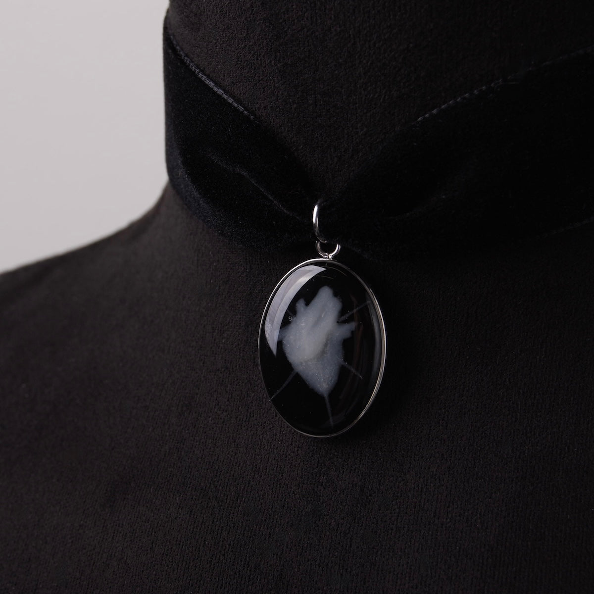 choker in velluto nero con ovale cuore anatomico spinato su busto espositivo