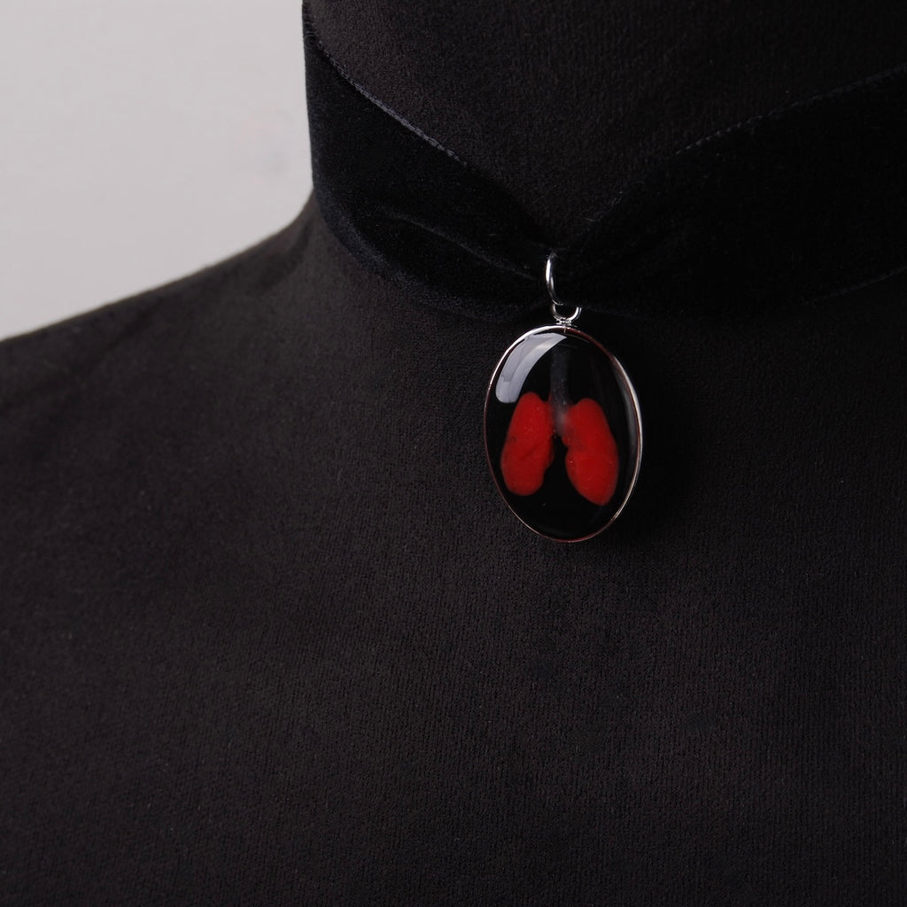 choker in velluto nero con pendente ovale con miniatura di polmoni, su busto espositivo in velluto, vista 3/4