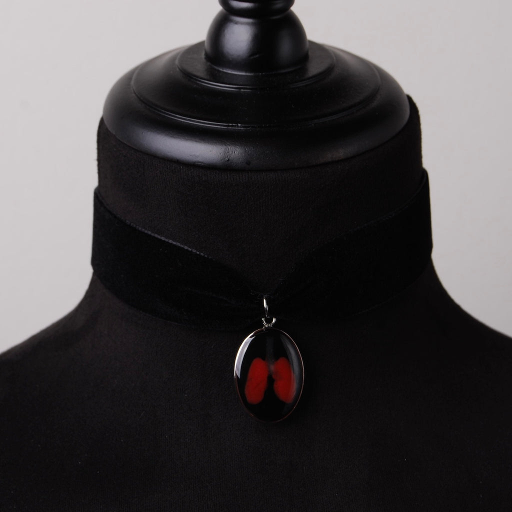choker in velluto nero con pendente ovale con miniatura di polmoni, su busto espositivo in velluto