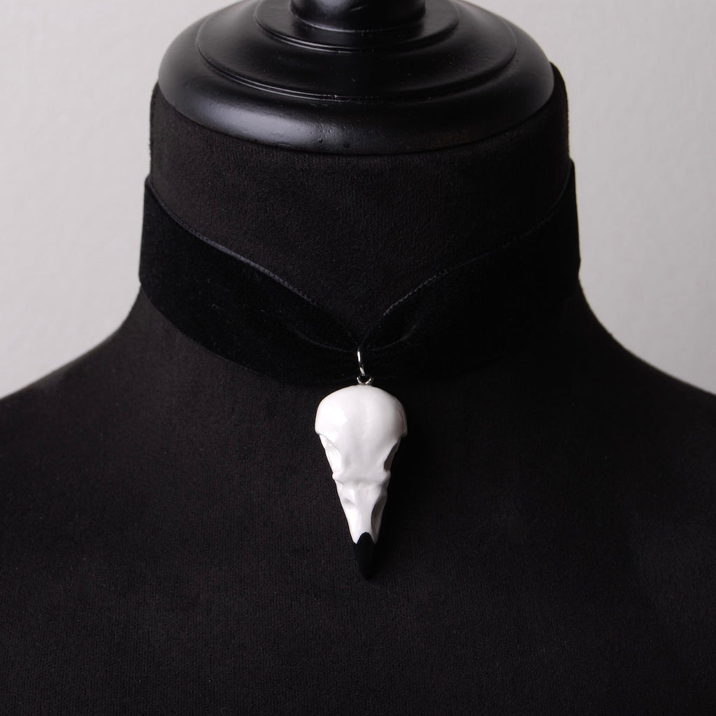choker in velluto nero con pendente teschio di corvo indossato su busto espositivo