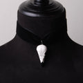 choker in velluto nero con pendente teschio di corvo indossato su busto espositivo