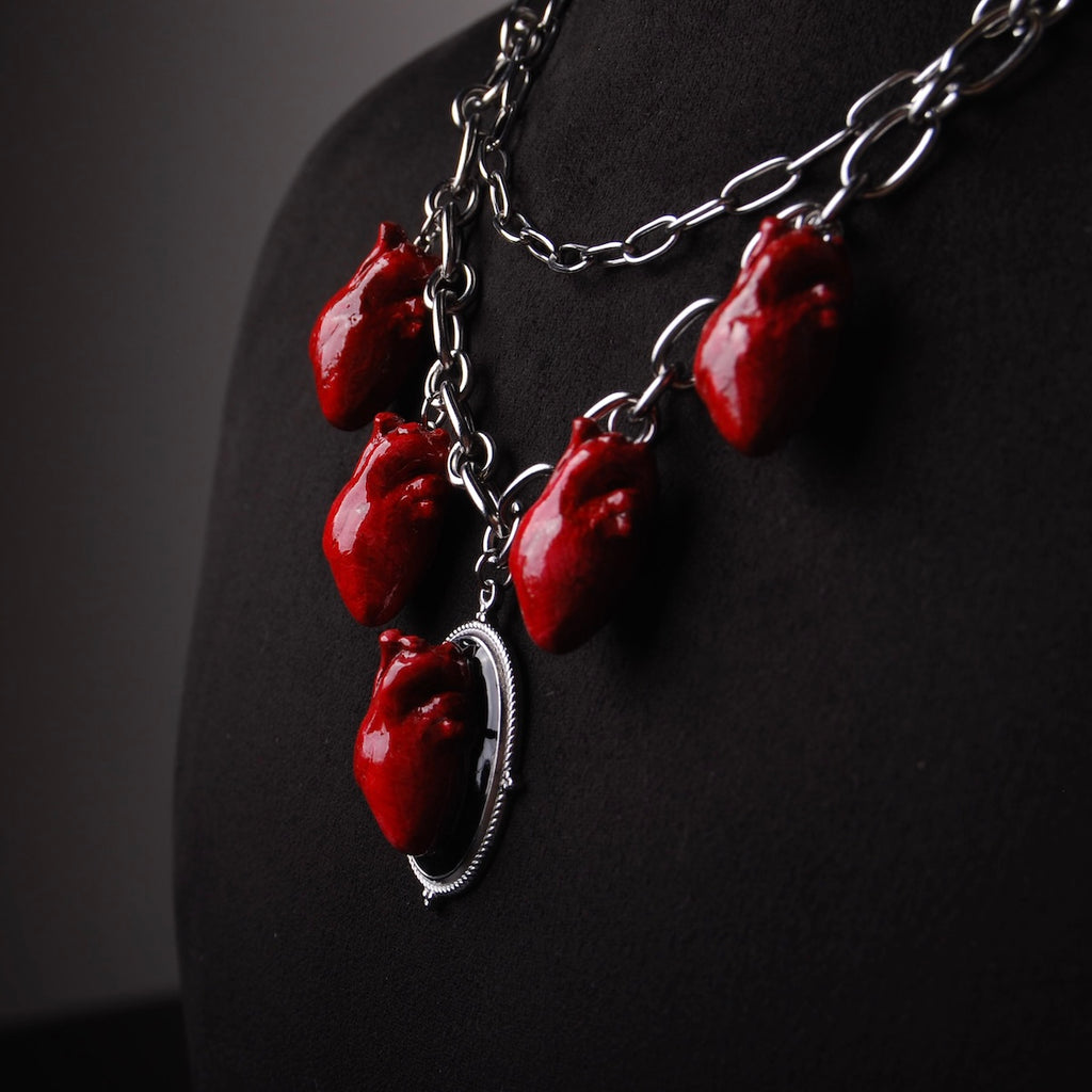 collana a catena doppia con 5 cuori anatomici pendenti, vista laterale su busto espositivo