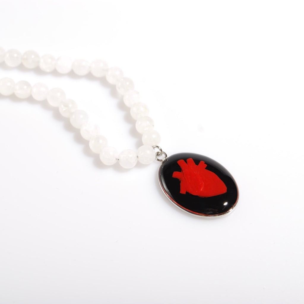 collana con sfere di pietra di luna e pendente centrale ovale con cuore anatomico , vista 3/4
