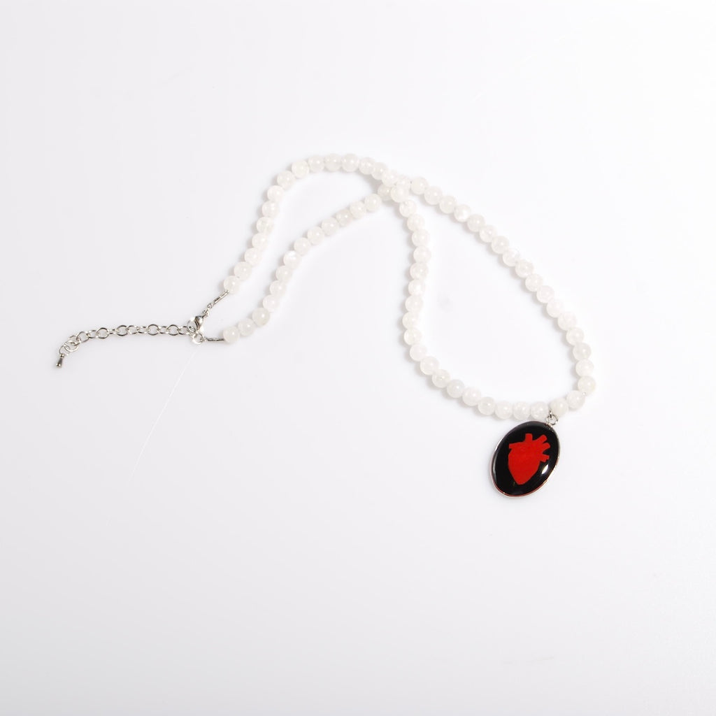 collana con sfere di pietra di luna e pendente centrale ovale con cuore anatomico, vista dall'alto