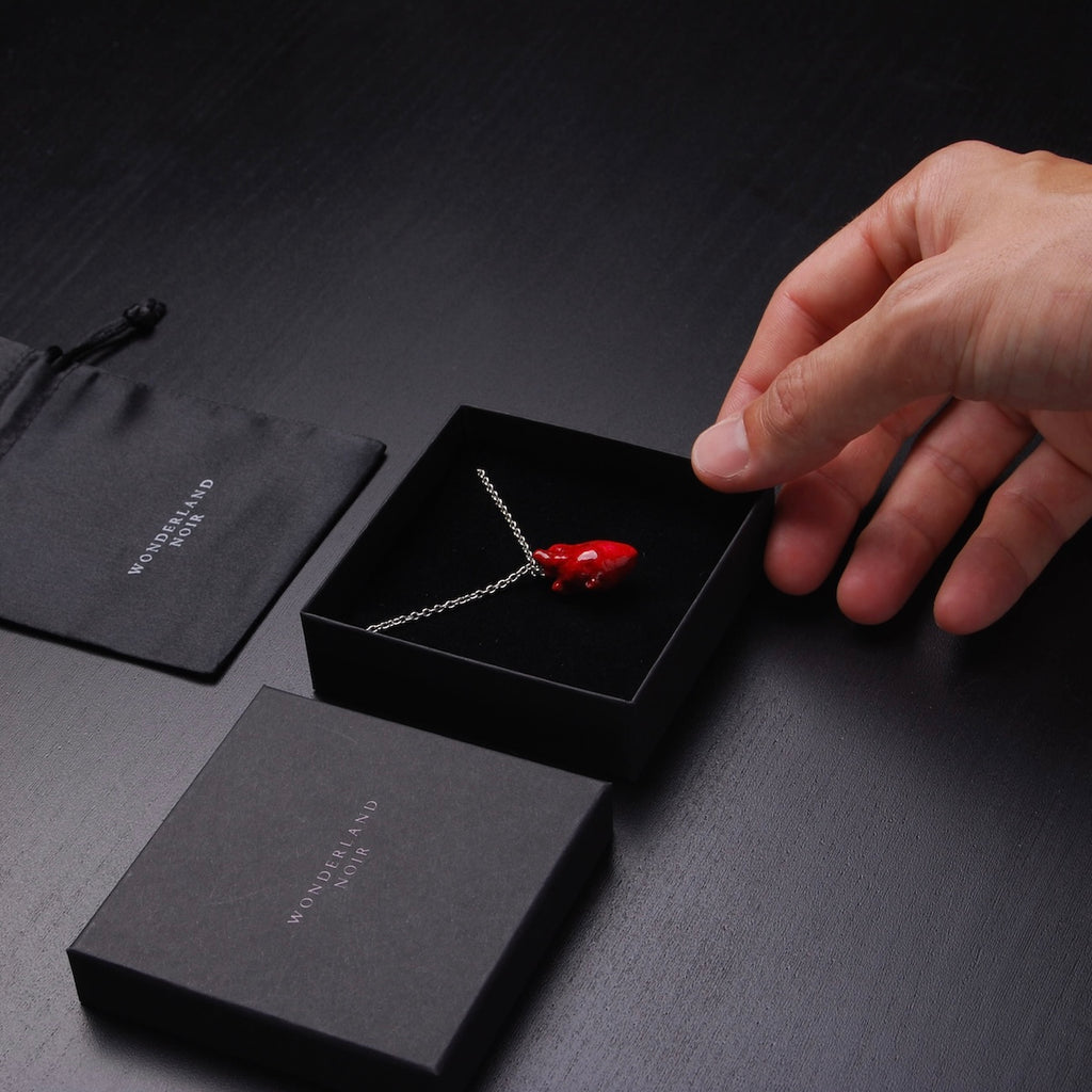collana catena sottile con cuore anatomico rosso dentro ad una scatolina sorretta da una mano