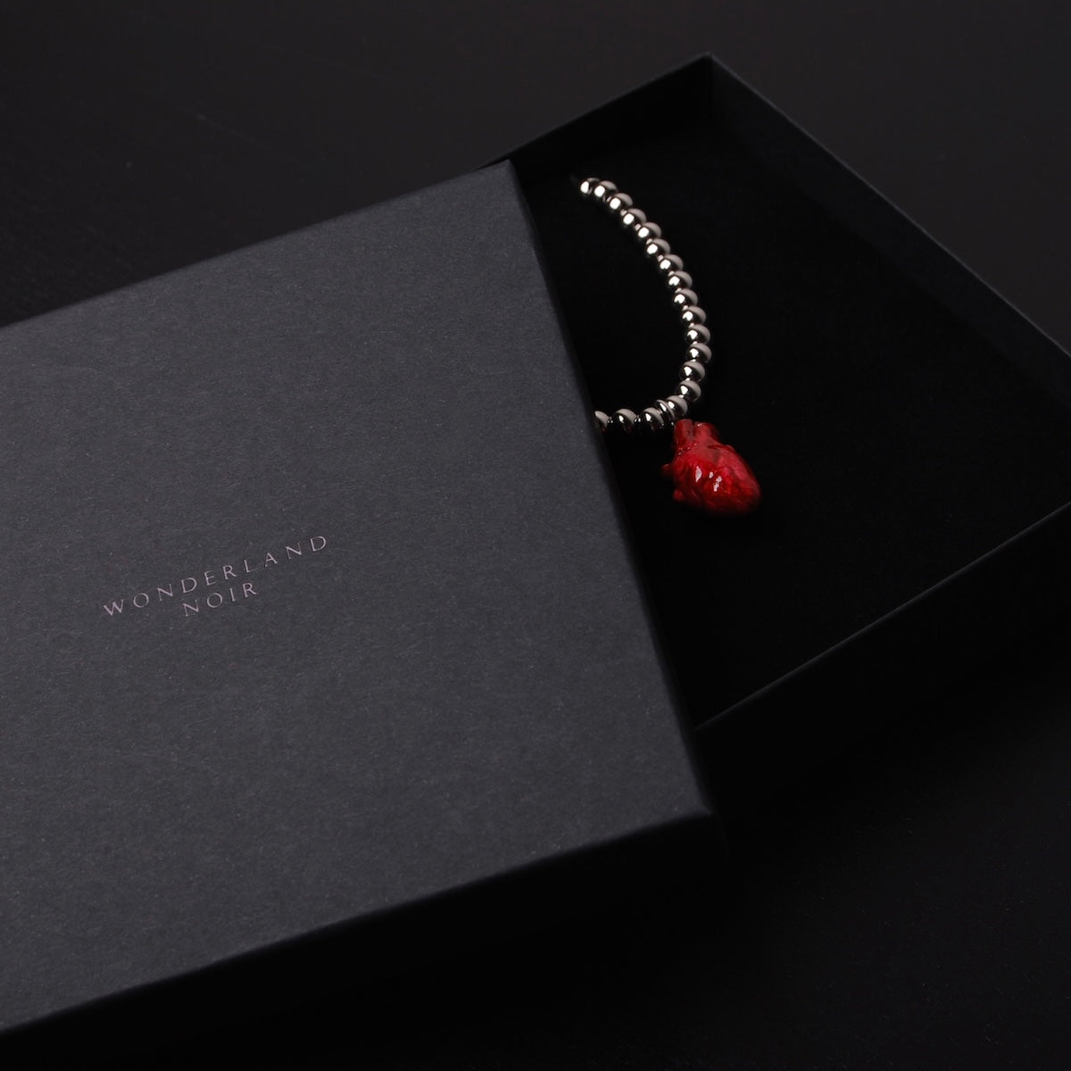 collana a sfere con pendente cuore anatomico rosso dentro ad una scatolina nera