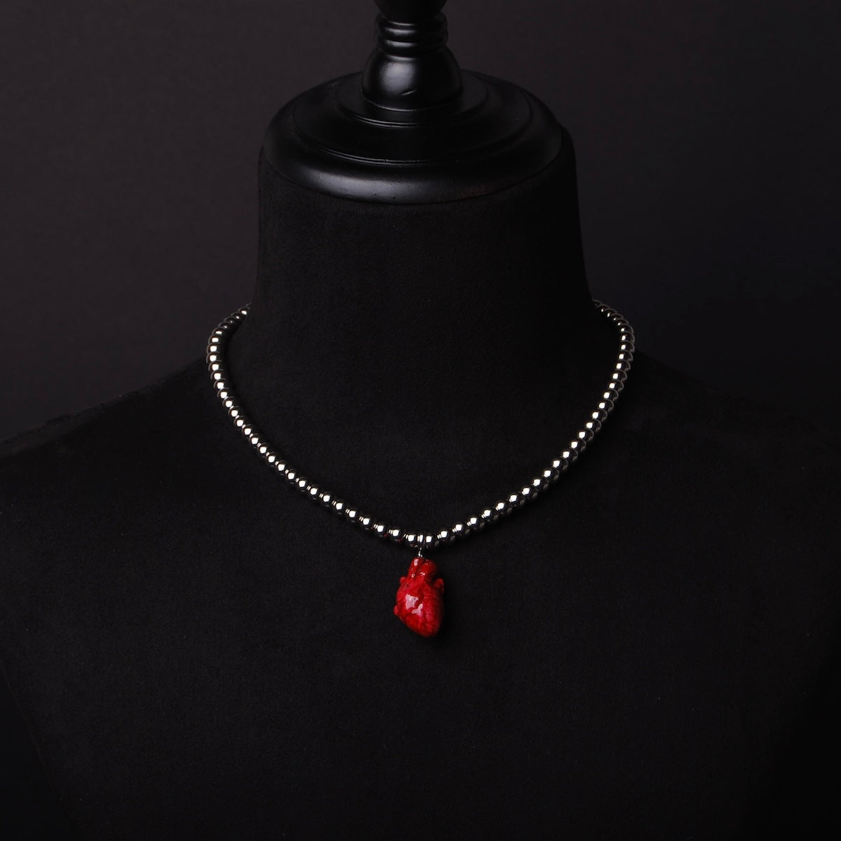 collana a sfere con pendente cuore anatomico rosso su busto espositivo