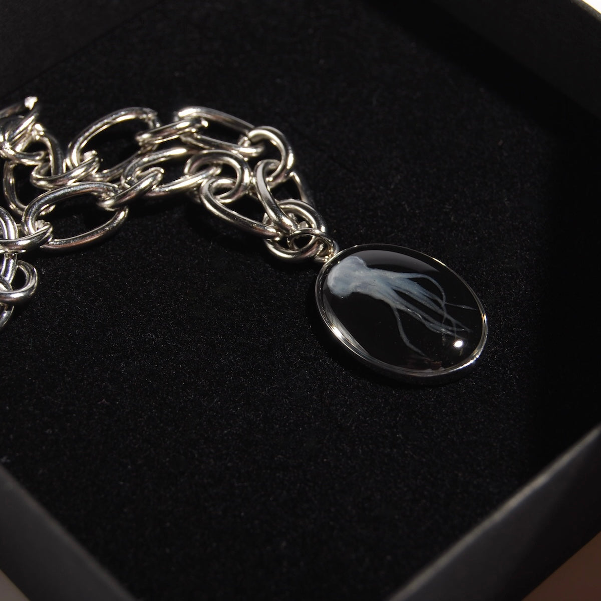 collana catena in acciaio con pendente medusa marina dentro ad una scatolina nera, dettaglio del pendente