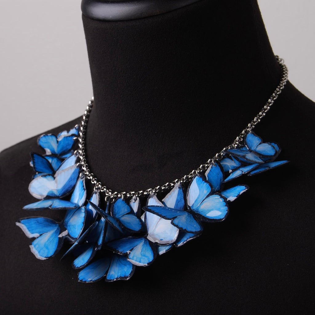 collana con sciame di farfalle blue morpho su busto espositivo, vista 3/4