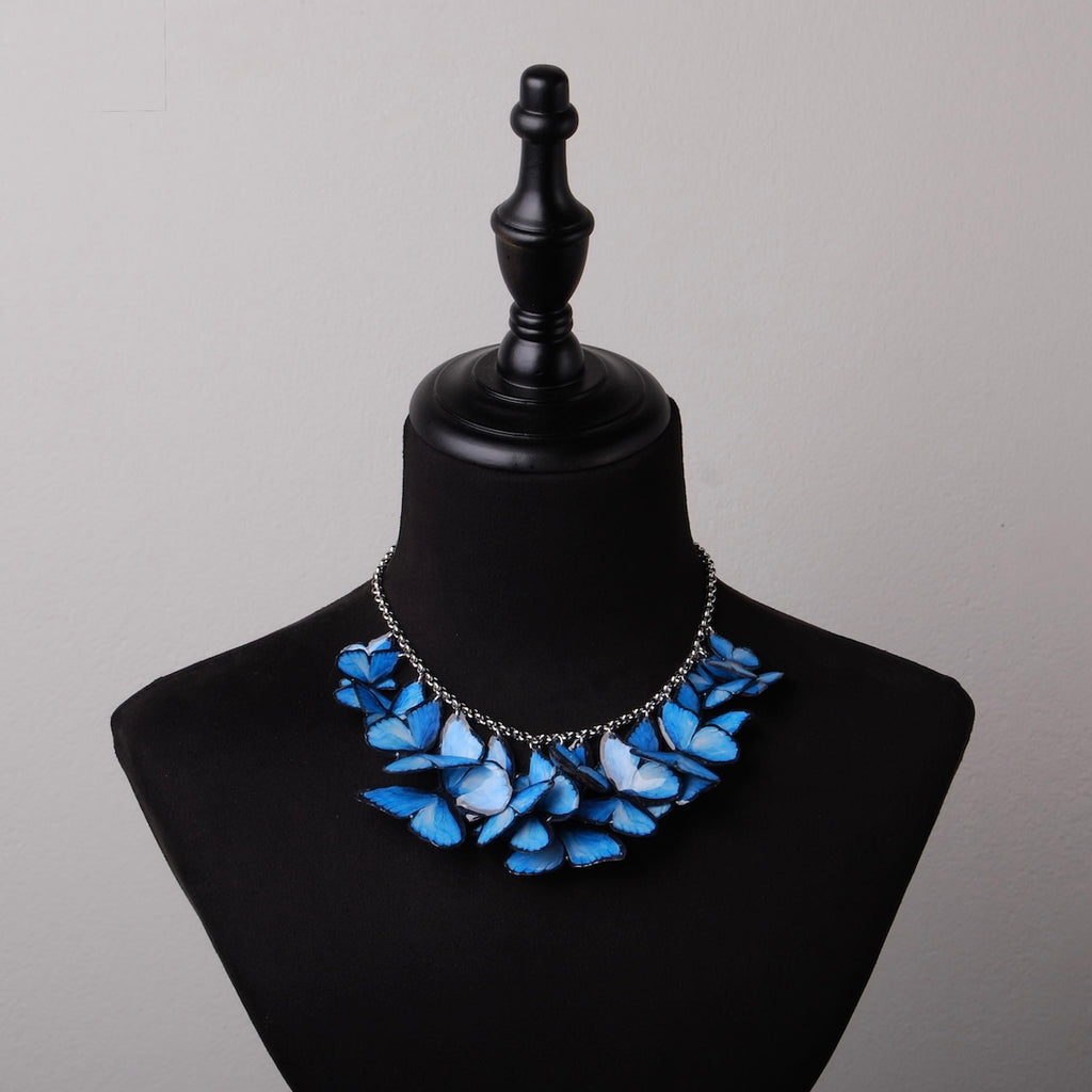 collana con sciame di farfalle blue morpho su busto espositivo, vista frontale