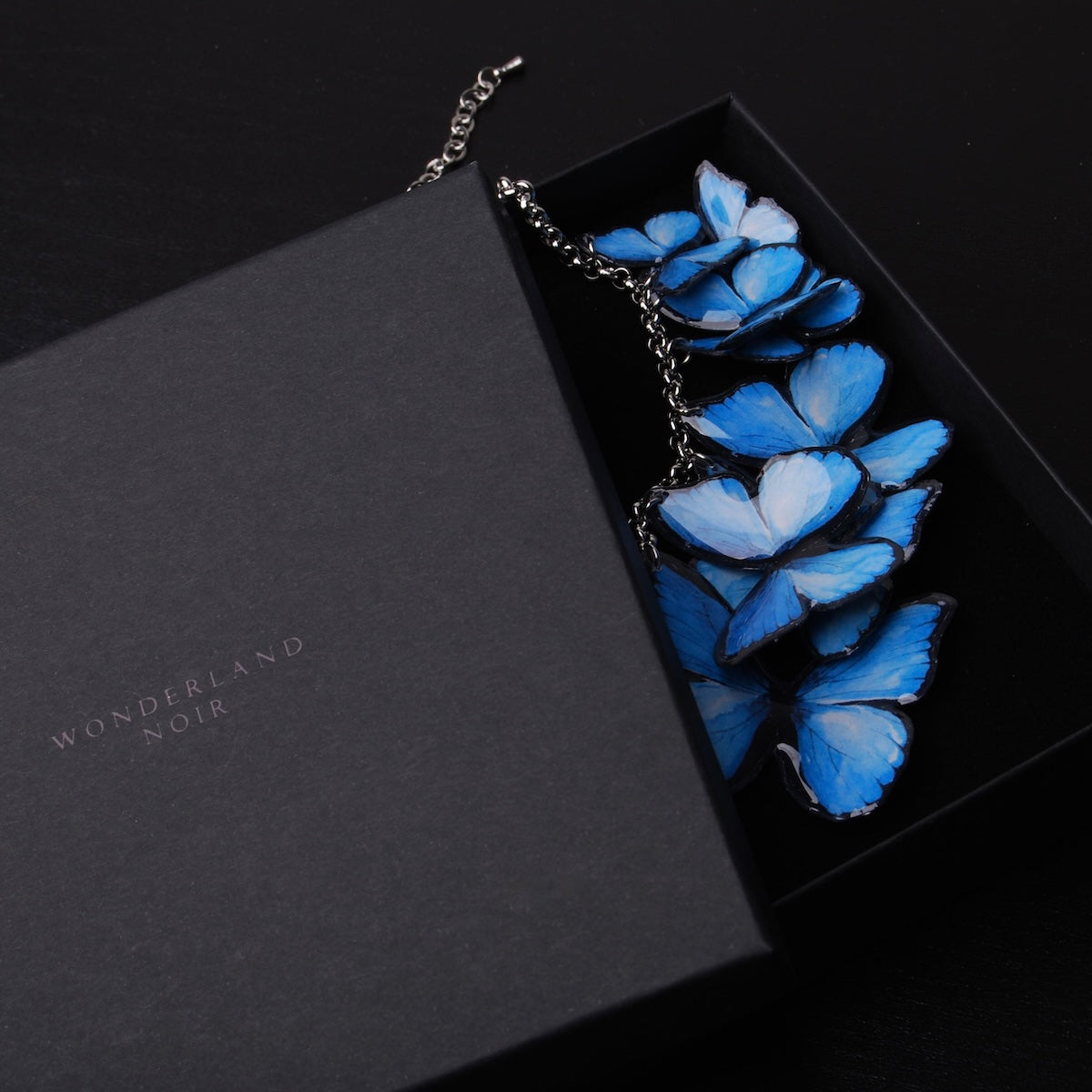 collana con sciame di farfalle blue morpho dentro ad una scatolina per gioielli nera