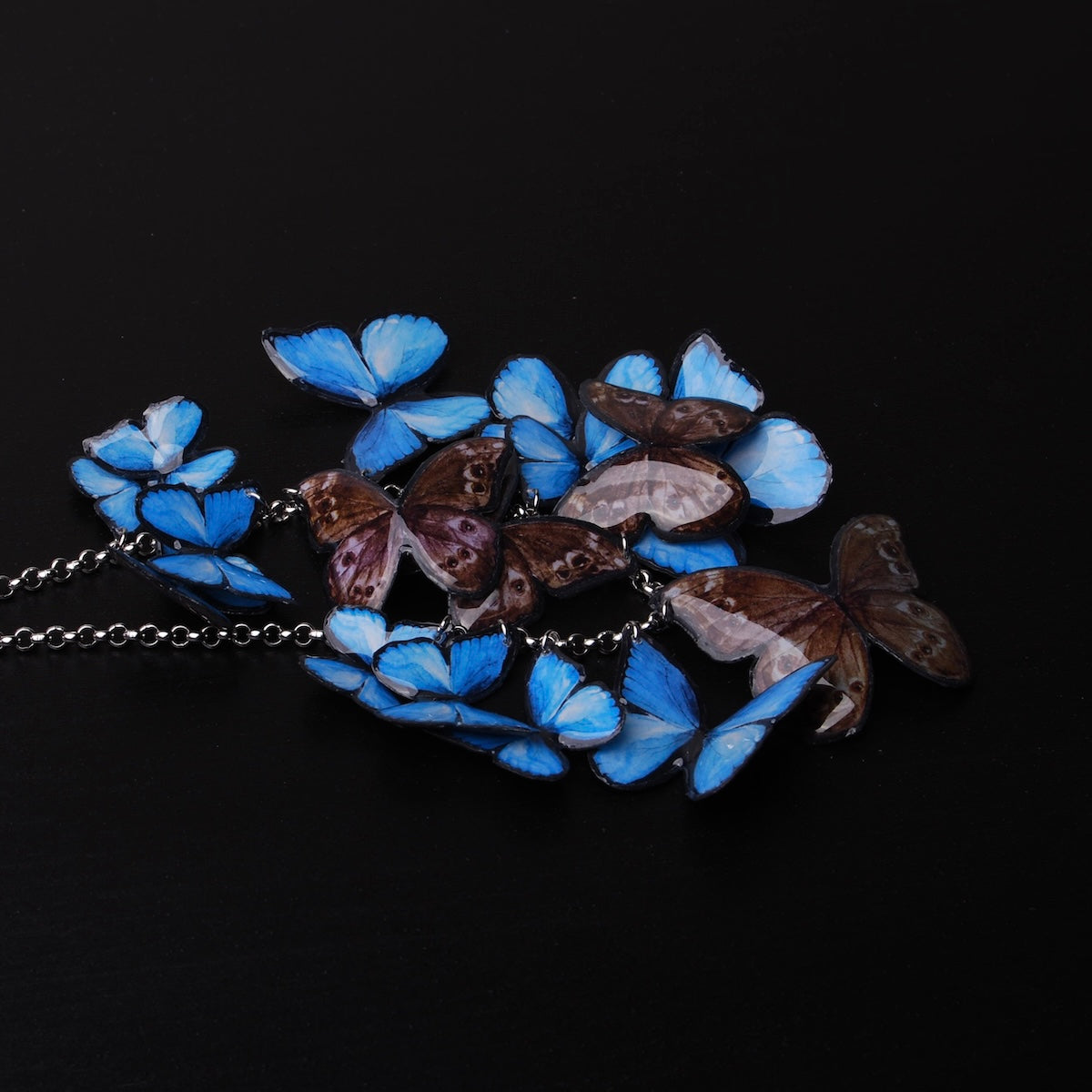 collana con sciame di farfalle blue morpho, dettaglio blu e marrone delle farfalle