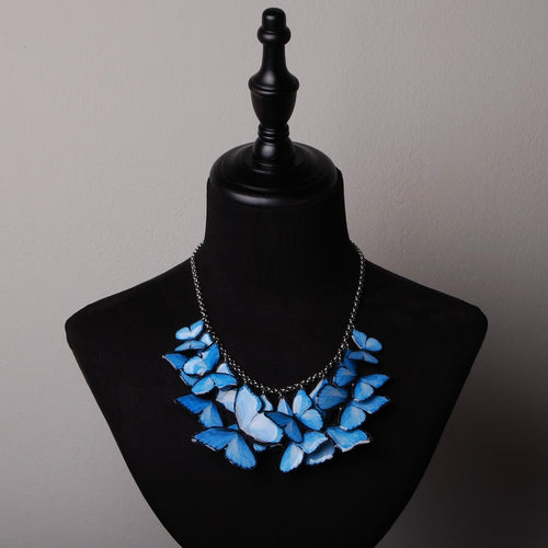 collana sciame di farfalle blu su busto espositivo