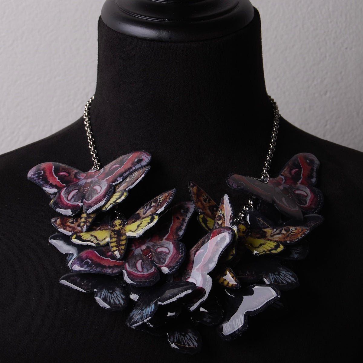 collana sciame di farfalle e falene su busto espositivo, vista ravvicinata