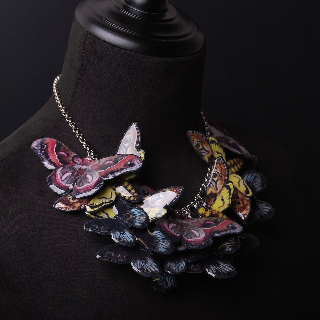 collana sciame di farfalle e falene su busto espositivo, vista 3/4