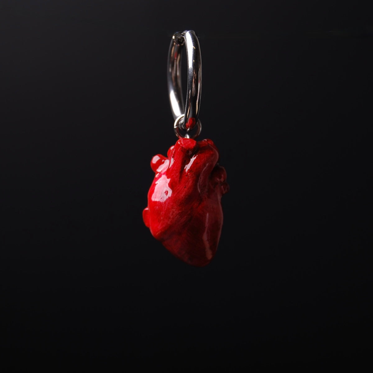 orecchini singolo a cerchio con cuore anatomico rosso, vista frontale ravvicinata