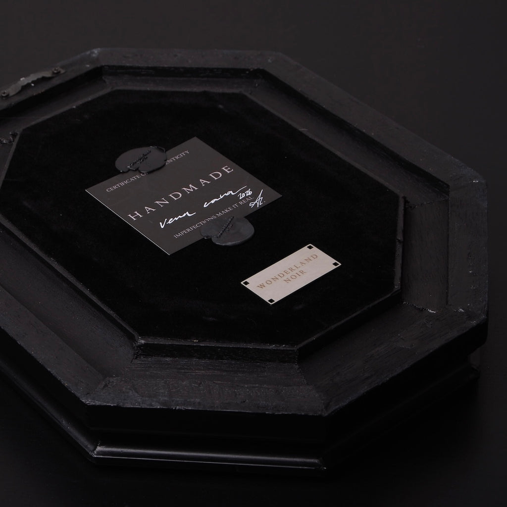 retro di un quadro a cornice ottagonale nero con targhetta e certificato di autenticità