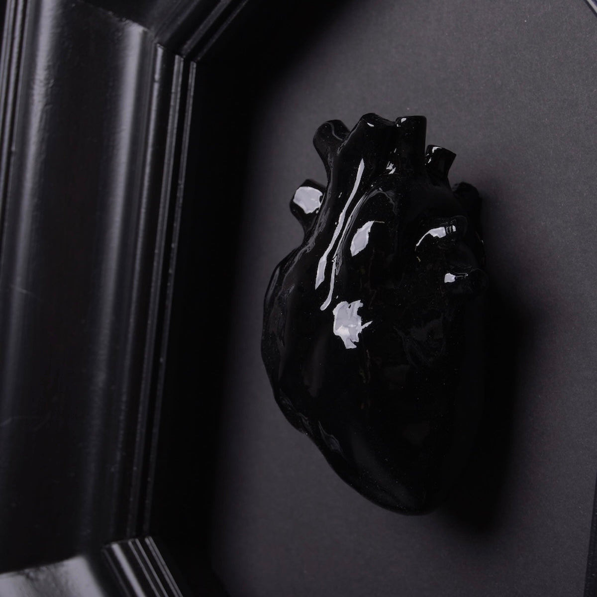 cuore anatomico nero al centro di una cornice nera